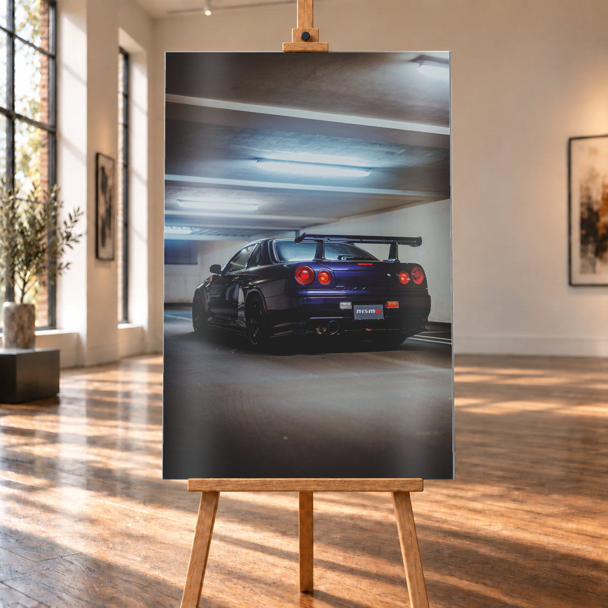 Dunkelvioletter Nissan Skyline R34 in tiefer Heckdreiviertelansicht in einem Parkhaus, mit vier runden roten Rückleuchten, großem Heckflügel, dunklen Rädern und kühlen Deckenleuchten; Visualisierung als Alu gebürstet-Wandbild, auf einer Holzstaffelei in einem hellen Galerieraum.