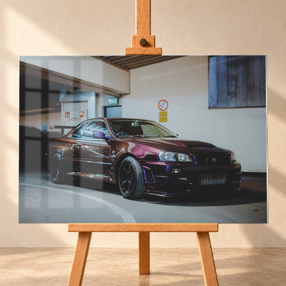 Dunkelvioletter Nissan Skyline R34 in einem Parkhaus, schräg von vorn fotografiert, mit schwarzen Rädern, großem Heckflügel und pink-violetten Lichtreflexionen auf der Karosserie; Visualisierung als Acrylglas-Wandbild, frontal auf einer Holzstaffelei.