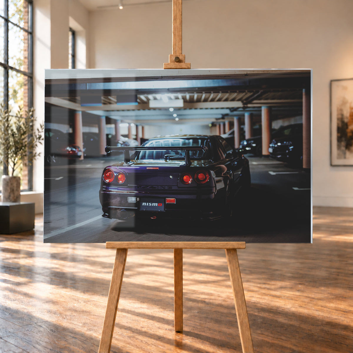 Heckansicht eines dunkelvioletten Nissan Skyline R34 mit großem Heckflügel und vier rot leuchtenden runden Rücklichtern auf einer überdachten Parkebene. Rötliche Säulen, Deckenbalken und unscharf abgestellte Fahrzeuge rahmen das Auto; kühles, gedämpftes Licht spiegelt sich auf der Karosserie; Visualisierung als Acrylglas-Wandbild, auf einer Holzstaffelei in einem hellen Galerieraum.