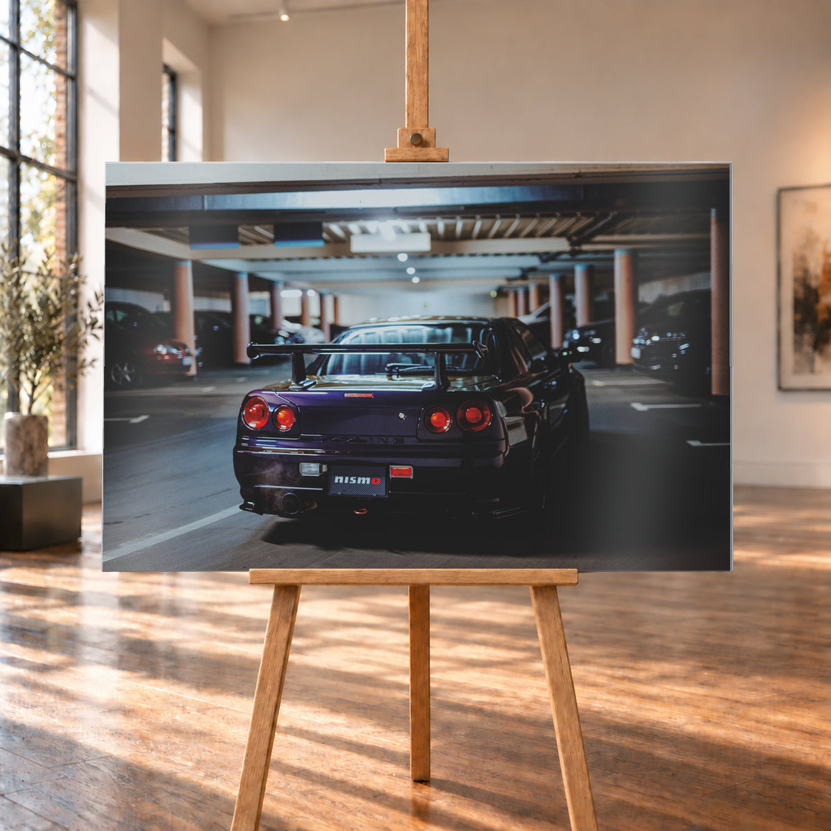 Heckansicht eines dunkelvioletten Nissan Skyline R34 mit großem Heckflügel und vier rot leuchtenden runden Rücklichtern auf einer überdachten Parkebene. Rötliche Säulen, Deckenbalken und unscharf abgestellte Fahrzeuge rahmen das Auto; kühles, gedämpftes Licht spiegelt sich auf der Karosserie; Visualisierung als Alu gebürstet-Wandbild, auf einer Holzstaffelei in einem hellen Galerieraum.
