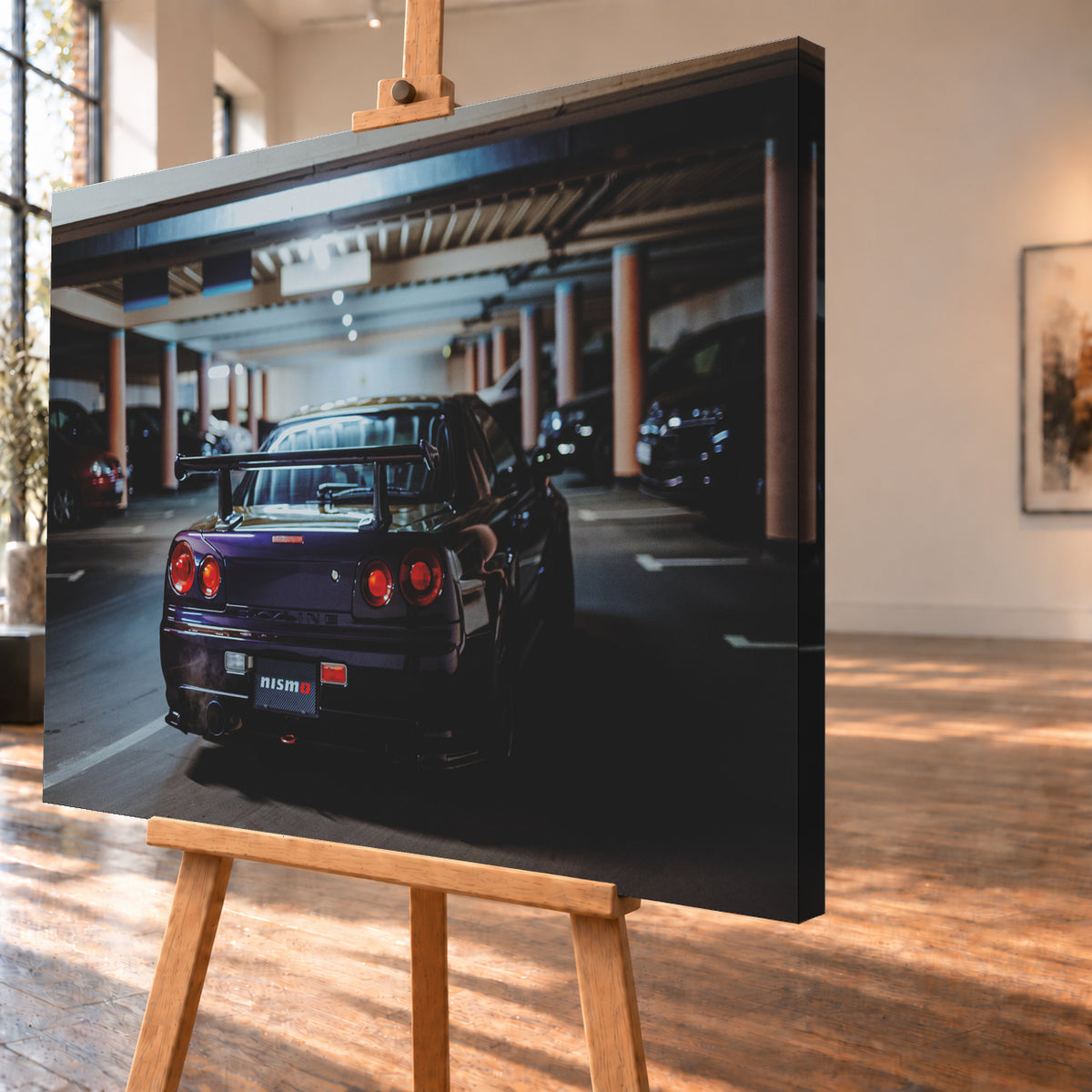 Heckansicht eines dunkelvioletten Nissan Skyline R34 mit großem Heckflügel und vier rot leuchtenden runden Rücklichtern auf einer überdachten Parkebene. Rötliche Säulen, Deckenbalken und unscharf abgestellte Fahrzeuge rahmen das Auto; kühles, gedämpftes Licht spiegelt sich auf der Karosserie; Visualisierung als Leinwand-Wandbild, schräg von der Seite auf einer Holzstaffelei.