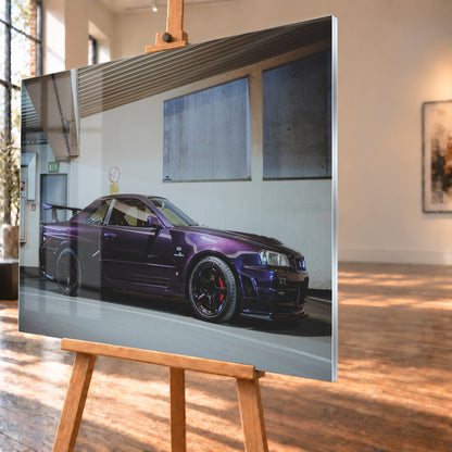 Violetter Nissan Skyline R34, nahezu seitlich mit der Front nach rechts, in einem hellen Parkgaragen-Innenraum; sichtbar sind schwarze Räder, rote Bremssättel und ein großer Heckflügel; Visualisierung als Acrylglas-Wandbild, schräg von der Seite auf einer Holzstaffelei.