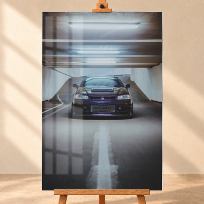 Dunkelvioletter Nissan Skyline R34 in zentraler Frontansicht auf der Zufahrt einer Parkgarage, beleuchtet von mehreren weißen Deckenleuchten und umgeben von grauen Wänden und Fahrbahnmarkierungen; Visualisierung als Acrylglas-Wandbild, frontal auf einer Holzstaffelei.