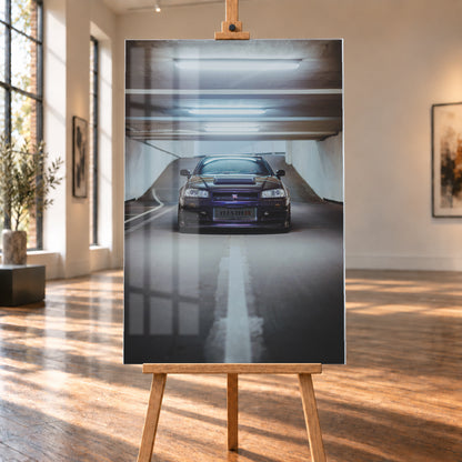 Dunkelvioletter Nissan Skyline R34 in zentraler Frontansicht auf der Zufahrt einer Parkgarage, beleuchtet von mehreren weißen Deckenleuchten und umgeben von grauen Wänden und Fahrbahnmarkierungen; Visualisierung als Acrylglas-Wandbild, auf einer Holzstaffelei in einem hellen Galerieraum.