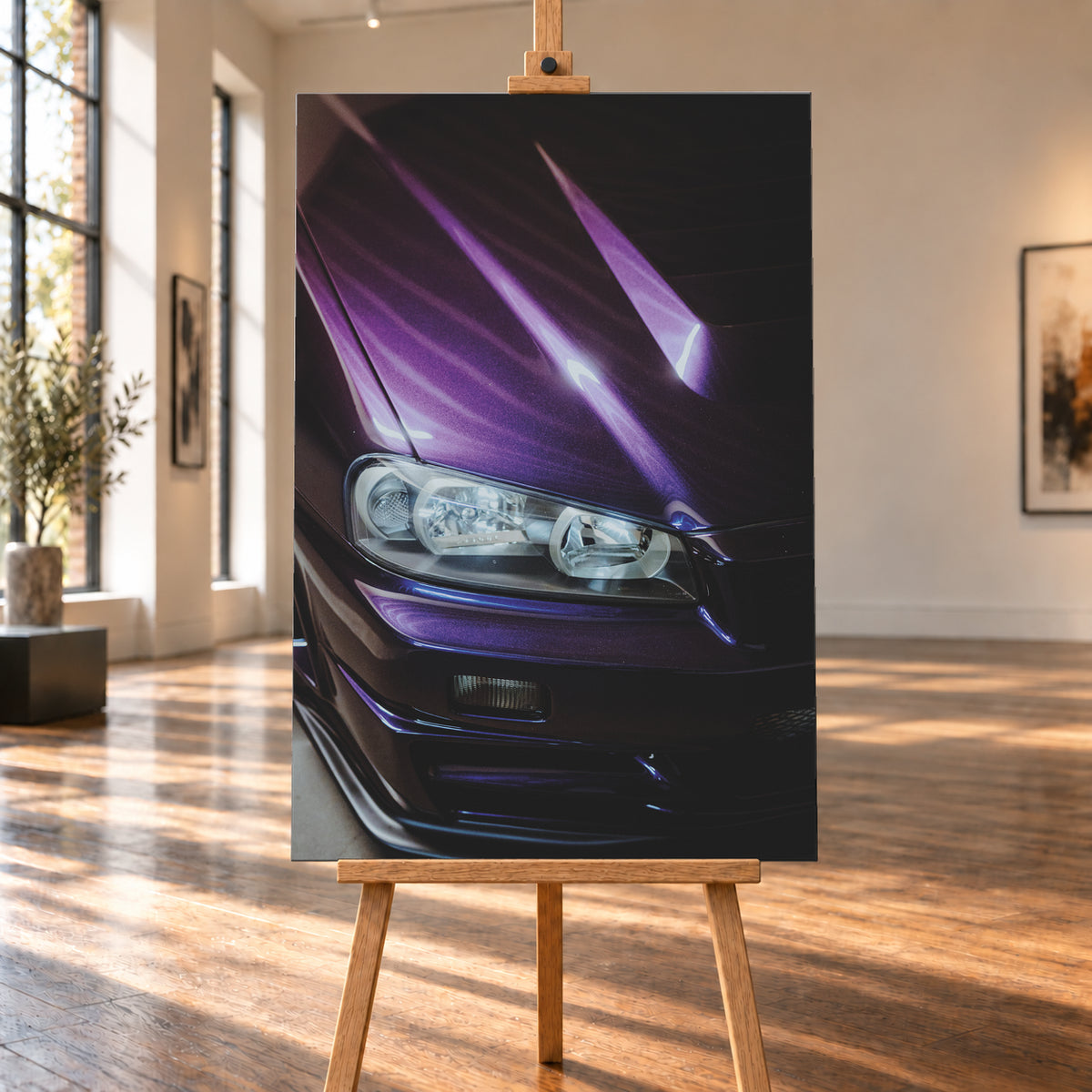Nahaufnahme der dunkelvioletten Front eines Nissan Skyline R34, schräg von vorn fotografiert. Ein Scheinwerfer und Teile des Stoßfängers sind sichtbar; helle violette Reflexe verlaufen über die Motorhaube vor dunklem Hintergrund; Visualisierung als Leinwand-Wandbild, auf einer Holzstaffelei in einem hellen Galerieraum.
