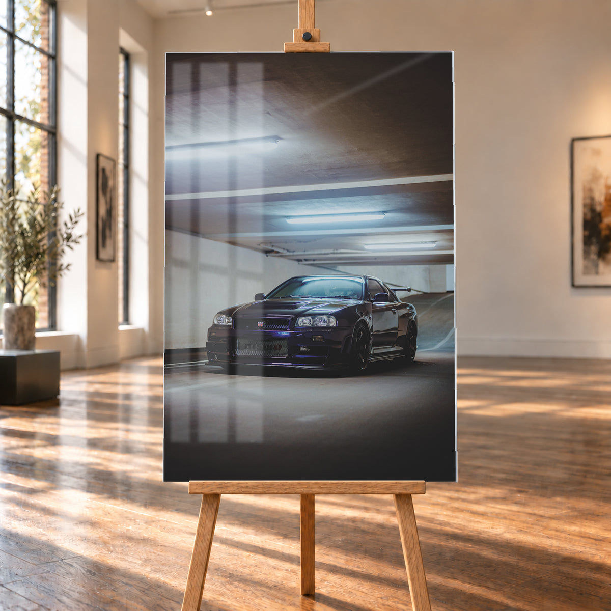 Dunkelvioletter Nissan Skyline R34 in Front-Dreiviertelansicht in einer Betonparkgarage. Kühle Deckenleuchten spiegeln sich auf der Karosserie; dunkle Räder, Seitenschweller und ein großer Heckflügel sind sichtbar. Das Hochformat zeigt viel dunkle Deckenfläche und eine ansteigende Rampe im Hintergrund; Visualisierung als Acrylglas-Wandbild, auf einer Holzstaffelei in einem hellen Galerieraum.