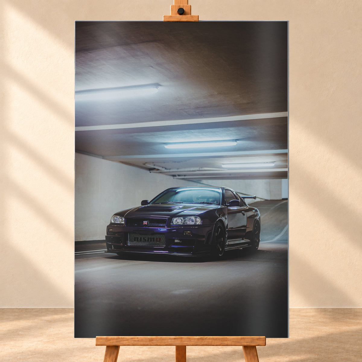 Dunkelvioletter Nissan Skyline R34 in Front-Dreiviertelansicht in einer Betonparkgarage. Kühle Deckenleuchten spiegeln sich auf der Karosserie; dunkle Räder, Seitenschweller und ein großer Heckflügel sind sichtbar. Das Hochformat zeigt viel dunkle Deckenfläche und eine ansteigende Rampe im Hintergrund; Visualisierung als Alu gebürstet-Wandbild, frontal auf einer Holzstaffelei.