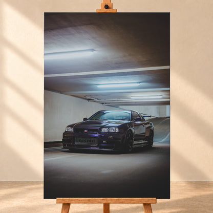 Dunkelvioletter Nissan Skyline R34 in Front-Dreiviertelansicht in einer Betonparkgarage. Kühle Deckenleuchten spiegeln sich auf der Karosserie; dunkle Räder, Seitenschweller und ein großer Heckflügel sind sichtbar. Das Hochformat zeigt viel dunkle Deckenfläche und eine ansteigende Rampe im Hintergrund; Visualisierung als Leinwand-Wandbild, frontal auf einer Holzstaffelei.