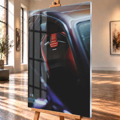 Nahaufnahme durch die geöffnete Tür eines violetten Nissan Skyline R34: Ein rot-schwarzer Sitz mit sichtbarem Nismo-Schriftzug steht im dunklen Innenraum; helle und blau-violette Reflexe verlaufen über Dachkante und Türrahmen; Visualisierung als Acrylglas-Wandbild, schräg von der Seite auf einer Holzstaffelei.