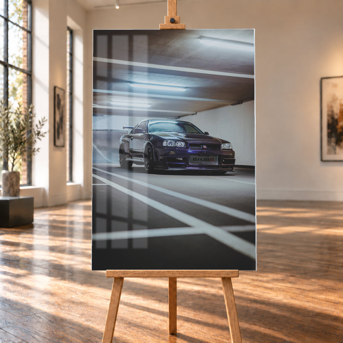 Dunkelvioletter Nissan Skyline R34 in niedriger Frontdreiviertelansicht in einer Beton-Parkgarage. Weiße Fahrbahnmarkierungen führen zum Fahrzeug; kühle Deckenleuchten spiegeln sich auf Haube und Scheibe. Sichtbar sind dunkle Räder und ein großer Heckflügel; Visualisierung als Acrylglas-Wandbild, auf einer Holzstaffelei in einem hellen Galerieraum.