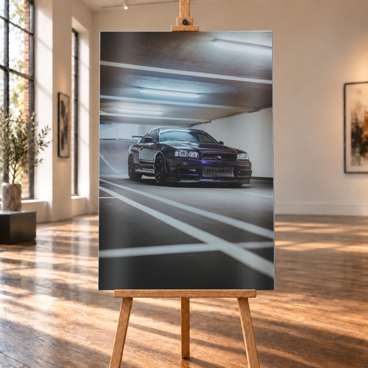Dunkelvioletter Nissan Skyline R34 in niedriger Frontdreiviertelansicht in einer Beton-Parkgarage. Weiße Fahrbahnmarkierungen führen zum Fahrzeug; kühle Deckenleuchten spiegeln sich auf Haube und Scheibe. Sichtbar sind dunkle Räder und ein großer Heckflügel; Visualisierung als Alu gebürstet-Wandbild, auf einer Holzstaffelei in einem hellen Galerieraum.