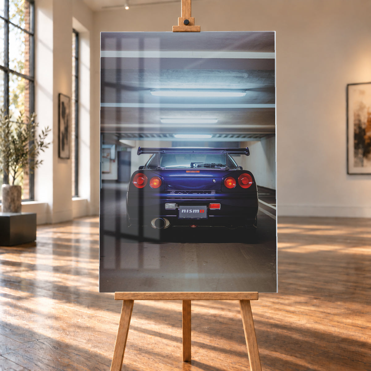 Mittige Heckansicht eines dunkelvioletten Nissan Skyline R34 in einer Parkgarage. Vier runde rote Rückleuchten, davon die beiden inneren orange leuchtend, ein großer Heckflügel, ein rundes Auspuffendrohr und ein Nismo-Schriftzug sind unter kühlen, horizontalen Deckenleuchten zu sehen; Visualisierung als Acrylglas-Wandbild, auf einer Holzstaffelei in einem hellen Galerieraum.