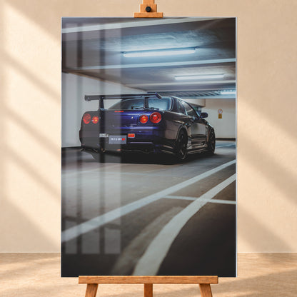 Dunkelvioletter Nissan Skyline R34 in tiefer Heck-Dreiviertelansicht in einer Beton-Parkgarage. Sichtbar sind vier rote Rundlichter, ein großer Heckflügel, dunkle Räder, ein großes Auspuffendrohr, weiße Fahrbahnlinien und kühle Deckenleuchten; Visualisierung als Acrylglas-Wandbild, frontal auf einer Holzstaffelei.
