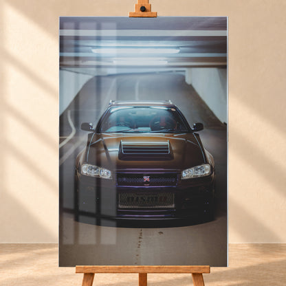 Frontale Ansicht eines dunkelvioletten Nissan Skyline R34 mit sichtbarem GT-R-Emblem in einer Tiefgarage, unter kühlen Deckenleuchten vor einer ansteigenden Fahrbahn; Visualisierung als Acrylglas-Wandbild, frontal auf einer Holzstaffelei.