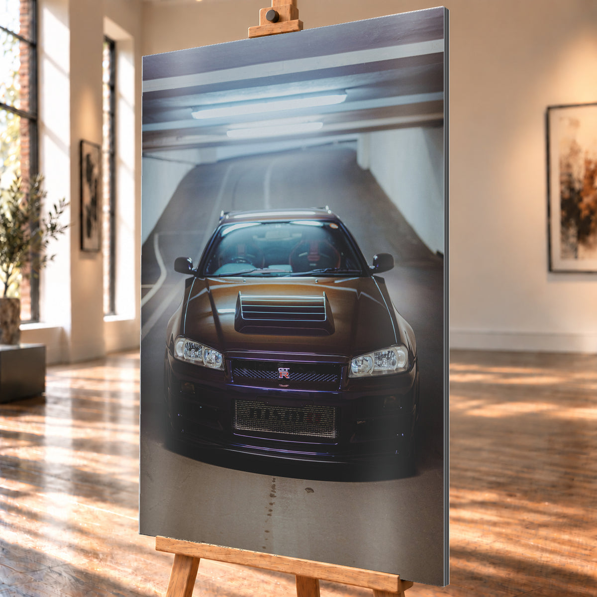Frontale Ansicht eines dunkelvioletten Nissan Skyline R34 mit sichtbarem GT-R-Emblem in einer Tiefgarage, unter kühlen Deckenleuchten vor einer ansteigenden Fahrbahn; Visualisierung als Alu gebürstet-Wandbild, schräg von der Seite auf einer Holzstaffelei.
