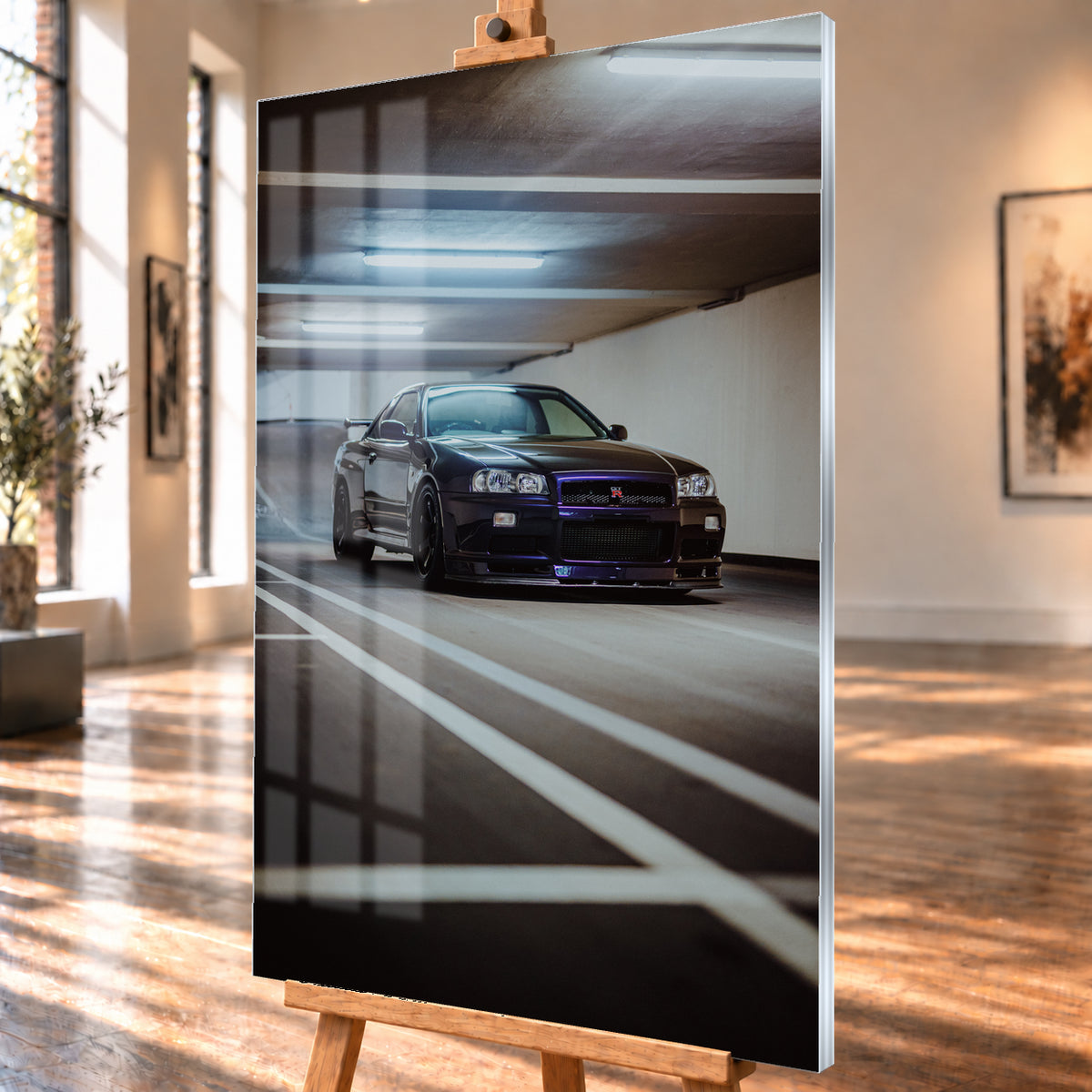 Dunkler Nissan Skyline R34 GT-R in niedriger Front-Dreiviertelansicht in einer Beton-Parkgarage, mit violett-blauen Reflexen, dunklen Rädern, Heckflügel, weißen Fahrbahnlinien und kühlen Deckenleuchten; Visualisierung als Acrylglas-Wandbild, schräg von der Seite auf einer Holzstaffelei.