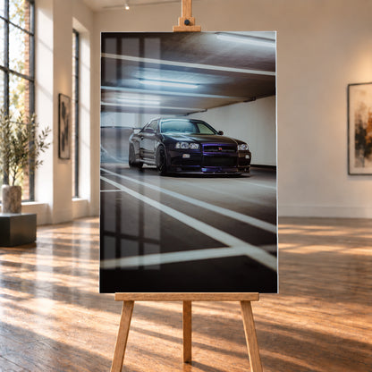 Dunkler Nissan Skyline R34 GT-R in niedriger Front-Dreiviertelansicht in einer Beton-Parkgarage, mit violett-blauen Reflexen, dunklen Rädern, Heckflügel, weißen Fahrbahnlinien und kühlen Deckenleuchten; Visualisierung als Acrylglas-Wandbild, auf einer Holzstaffelei in einem hellen Galerieraum.
