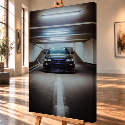 Dunkler Nissan Skyline R34 in frontaler Ansicht auf einer Betonrampe, unter kühlen weißen Deckenleuchten, mit mittiger Fahrbahnmarkierung und violettblauen Reflexen an Kühlergrill und Frontschürze; Visualisierung als Leinwand-Wandbild, schräg von der Seite auf einer Holzstaffelei.