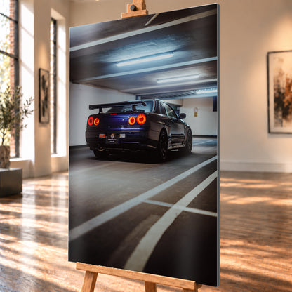 Dunkelblauer Nissan Skyline R34 in tiefer Dreiviertel-Heckansicht in einer Parkgarage; vier rote Rundrücklichter leuchten unter kühlen Deckenlampen, weiße Bodenlinien führen durch das Hochformat; Visualisierung als Alu gebürstet-Wandbild, schräg von der Seite auf einer Holzstaffelei.
