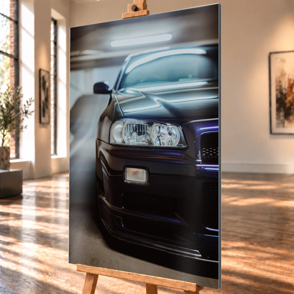 Dunkler Nissan Skyline in naher, leicht versetzter Frontansicht in einem Parkhaus. Sichtbar sind Scheinwerfer, Stoßfänger, Motorhaube, Windschutzscheibe und Seitenspiegel mit kühlen blau-violetten Lichtreflexen; Visualisierung als Alu gebürstet-Wandbild, schräg von der Seite auf einer Holzstaffelei.