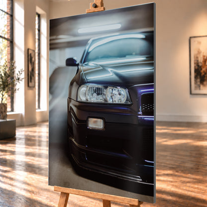 Dunkler Nissan Skyline in naher, leicht versetzter Frontansicht in einem Parkhaus. Sichtbar sind Scheinwerfer, Stoßfänger, Motorhaube, Windschutzscheibe und Seitenspiegel mit kühlen blau-violetten Lichtreflexen; Visualisierung als Alu gebürstet-Wandbild, schräg von der Seite auf einer Holzstaffelei.
