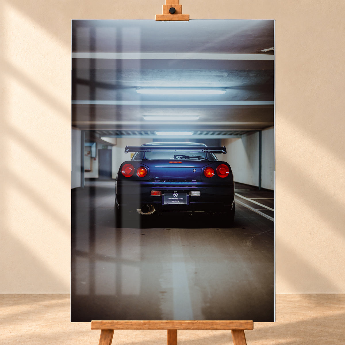 Dunkelblau bis violett wirkender Nissan Skyline R34 von hinten, mittig in einem Betonparkdeck unter kühlen Deckenleuchten; vier rote Rundlichter und ein großer Heckflügel sind sichtbar; Visualisierung als Acrylglas-Wandbild, frontal auf einer Holzstaffelei.