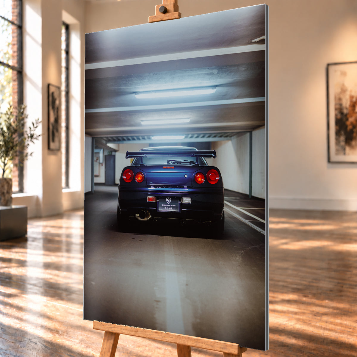 Dunkelblau bis violett wirkender Nissan Skyline R34 von hinten, mittig in einem Betonparkdeck unter kühlen Deckenleuchten; vier rote Rundlichter und ein großer Heckflügel sind sichtbar; Visualisierung als Alu gebürstet-Wandbild, schräg von der Seite auf einer Holzstaffelei.