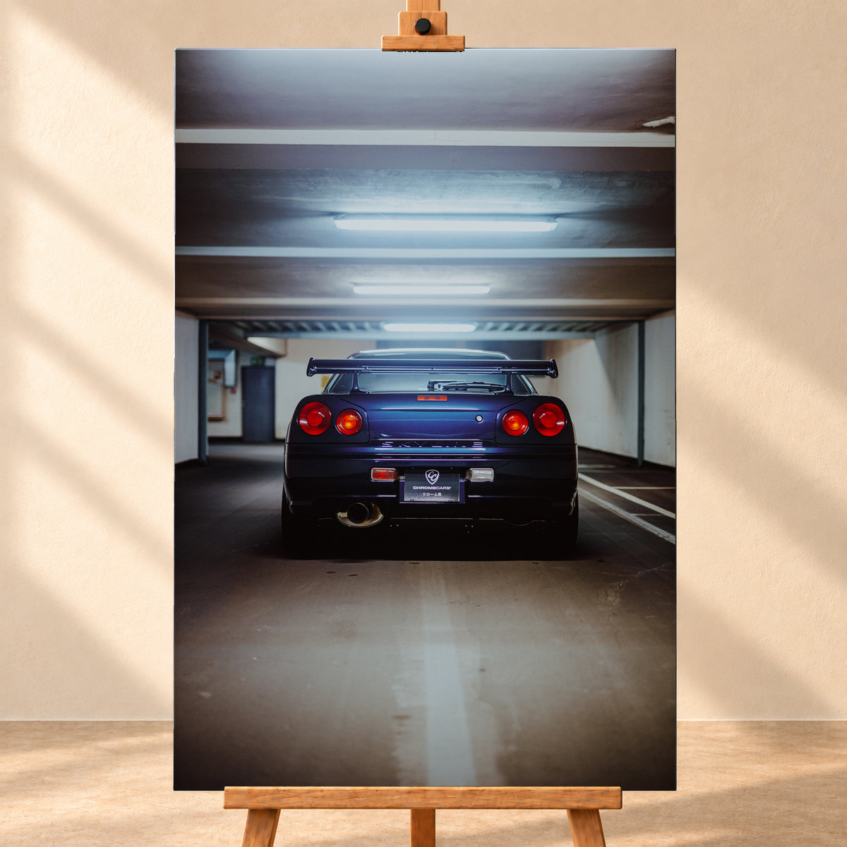 Dunkelblau bis violett wirkender Nissan Skyline R34 von hinten, mittig in einem Betonparkdeck unter kühlen Deckenleuchten; vier rote Rundlichter und ein großer Heckflügel sind sichtbar; Visualisierung als Leinwand-Wandbild, frontal auf einer Holzstaffelei.