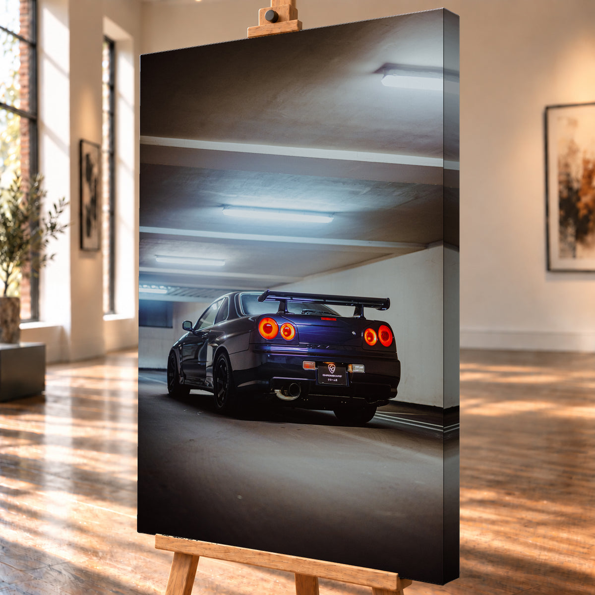 Dunkler Nissan Skyline R34 in niedriger Heck-Dreiviertelansicht mit vier rot leuchtenden Rundrückleuchten, großem Heckflügel und sichtbarem Auspuff in einer Beton-Parkgarage unter kühlen Deckenleuchten; Visualisierung als Leinwand-Wandbild, schräg von der Seite auf einer Holzstaffelei.