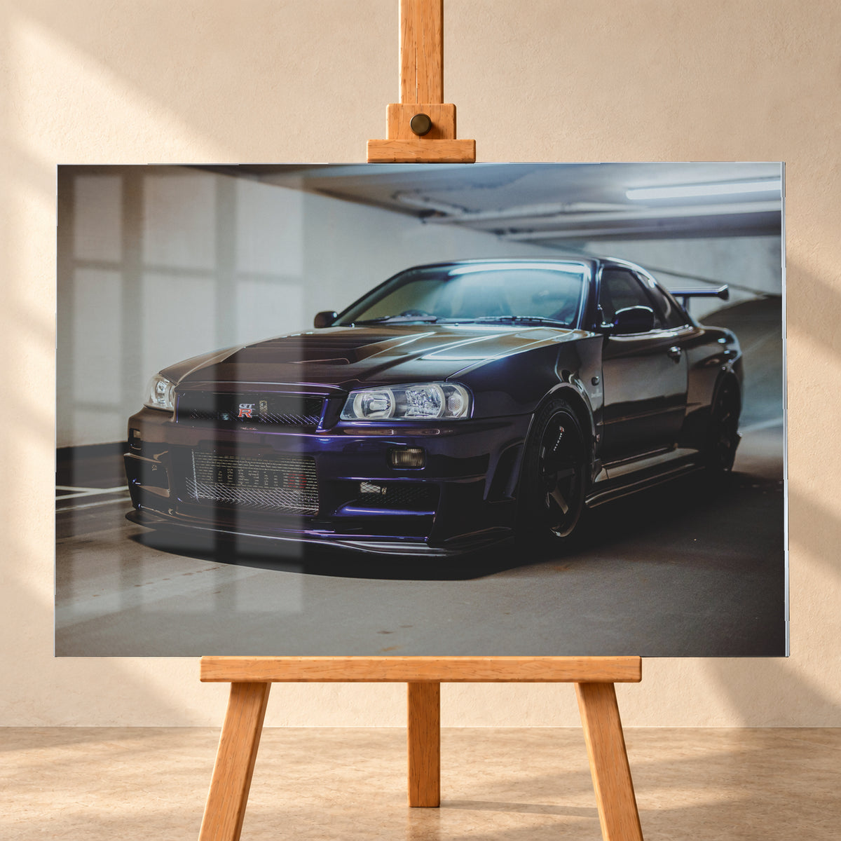 Dunkelvioletter Nissan Skyline R34 in Front-Dreiviertelansicht auf einem Parkdeck, mit schwarzem Kühlergrill, dunklen Rädern und großem Heckflügel. Helle Deckenleuchten spiegeln sich auf Motorhaube, Windschutzscheibe und Dach; Betonwand und Bodenmarkierungen rahmen das Fahrzeug; Visualisierung als Acrylglas-Wandbild, frontal auf einer Holzstaffelei.
