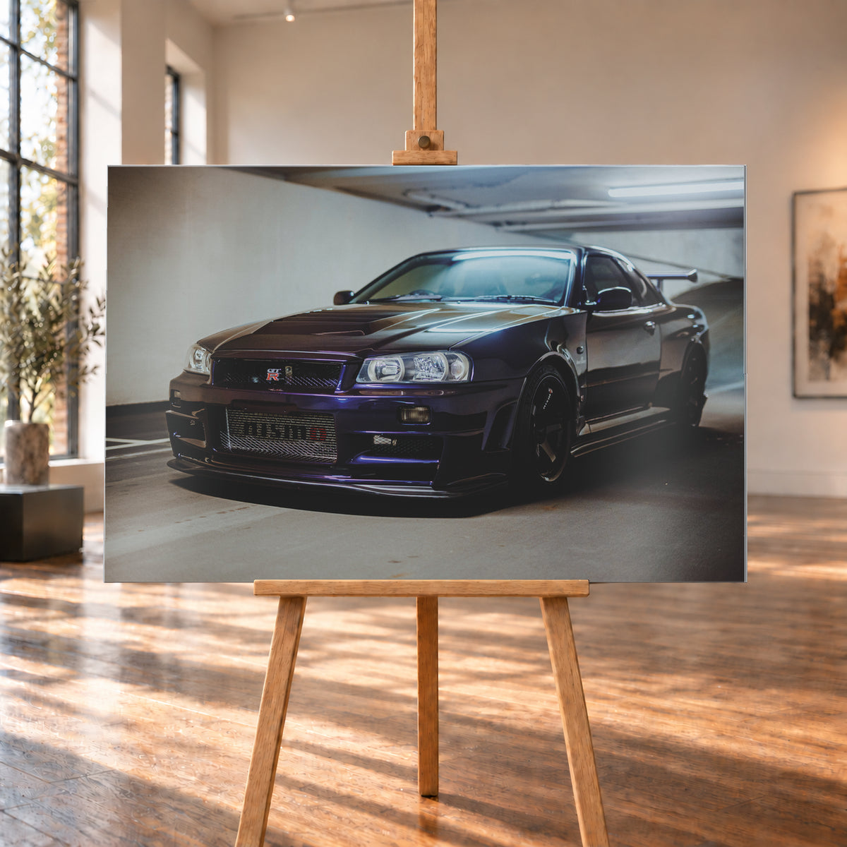Dunkelvioletter Nissan Skyline R34 in Front-Dreiviertelansicht auf einem Parkdeck, mit schwarzem Kühlergrill, dunklen Rädern und großem Heckflügel. Helle Deckenleuchten spiegeln sich auf Motorhaube, Windschutzscheibe und Dach; Betonwand und Bodenmarkierungen rahmen das Fahrzeug; Visualisierung als Alu gebürstet-Wandbild, auf einer Holzstaffelei in einem hellen Galerieraum.