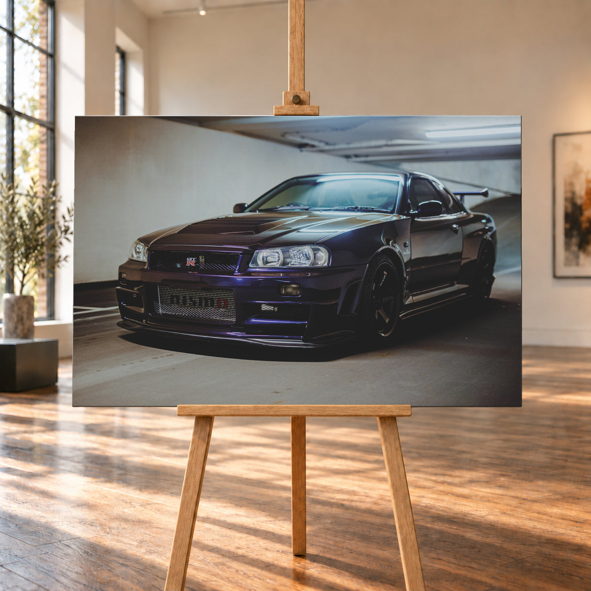 Dunkelvioletter Nissan Skyline R34 in Front-Dreiviertelansicht auf einem Parkdeck, mit schwarzem Kühlergrill, dunklen Rädern und großem Heckflügel. Helle Deckenleuchten spiegeln sich auf Motorhaube, Windschutzscheibe und Dach; Betonwand und Bodenmarkierungen rahmen das Fahrzeug; Visualisierung als Leinwand-Wandbild, auf einer Holzstaffelei in einem hellen Galerieraum.