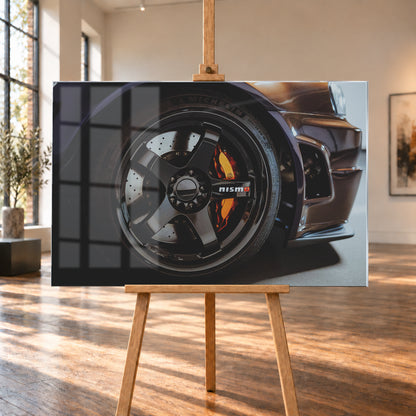 Nahaufnahme der Frontpartie eines dunkelviolett-bronze schimmernden Nissan Skyline R34 mit schwarzem Rad, sichtbarem NISMO-Schriftzug, gelochter Bremsscheibe und orange-rotem Bremssattel bei kontrastreichem Licht; Visualisierung als Acrylglas-Wandbild, auf einer Holzstaffelei in einem hellen Galerieraum.