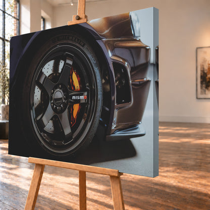Nahaufnahme der Frontpartie eines dunkelviolett-bronze schimmernden Nissan Skyline R34 mit schwarzem Rad, sichtbarem NISMO-Schriftzug, gelochter Bremsscheibe und orange-rotem Bremssattel bei kontrastreichem Licht; Visualisierung als Leinwand-Wandbild, schräg von der Seite auf einer Holzstaffelei.
