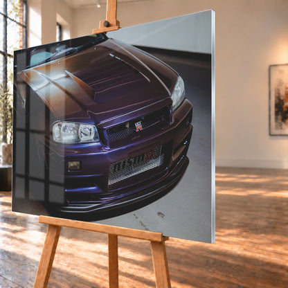 Nahes Frontporträt eines Nissan Skyline R34 in violett schimmerndem Lack, leicht von oben fotografiert, mit konturierter Motorhaube, Scheinwerfern, Kühlergrill und breiten Lufteinlässen in einem hellen Innenraum; Visualisierung als Acrylglas-Wandbild, schräg von der Seite auf einer Holzstaffelei.