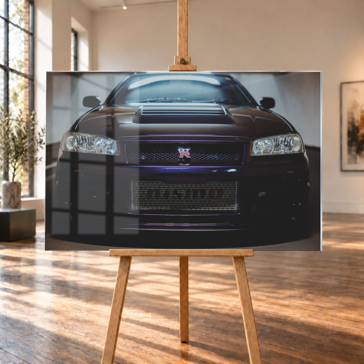 Symmetrische frontale Nahaufnahme eines dunkelvioletten Nissan Skyline R34 vor hellen Wänden. Sichtbar sind rechteckige Scheinwerfer, GT-R-Emblem, Hauben-Lufteinlass, Kühlergitter und die große untere Gitteröffnung; kühles Licht spiegelt sich auf Haube und Windschutzscheibe; Visualisierung als Acrylglas-Wandbild, auf einer Holzstaffelei in einem hellen Galerieraum.