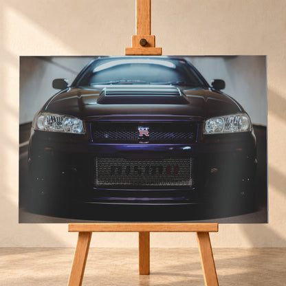 Symmetrische frontale Nahaufnahme eines dunkelvioletten Nissan Skyline R34 vor hellen Wänden. Sichtbar sind rechteckige Scheinwerfer, GT-R-Emblem, Hauben-Lufteinlass, Kühlergitter und die große untere Gitteröffnung; kühles Licht spiegelt sich auf Haube und Windschutzscheibe; Visualisierung als Alu gebürstet-Wandbild, frontal auf einer Holzstaffelei.