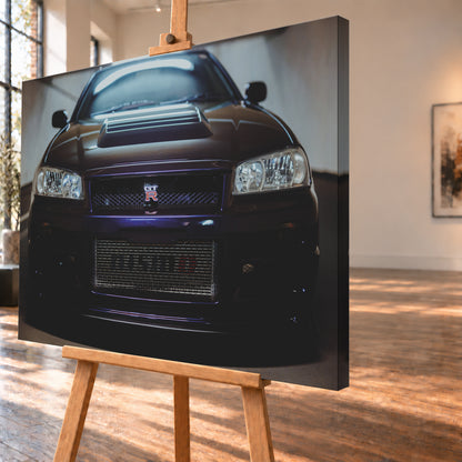 Symmetrische frontale Nahaufnahme eines dunkelvioletten Nissan Skyline R34 vor hellen Wänden. Sichtbar sind rechteckige Scheinwerfer, GT-R-Emblem, Hauben-Lufteinlass, Kühlergitter und die große untere Gitteröffnung; kühles Licht spiegelt sich auf Haube und Windschutzscheibe; Visualisierung als Leinwand-Wandbild, schräg von der Seite auf einer Holzstaffelei.