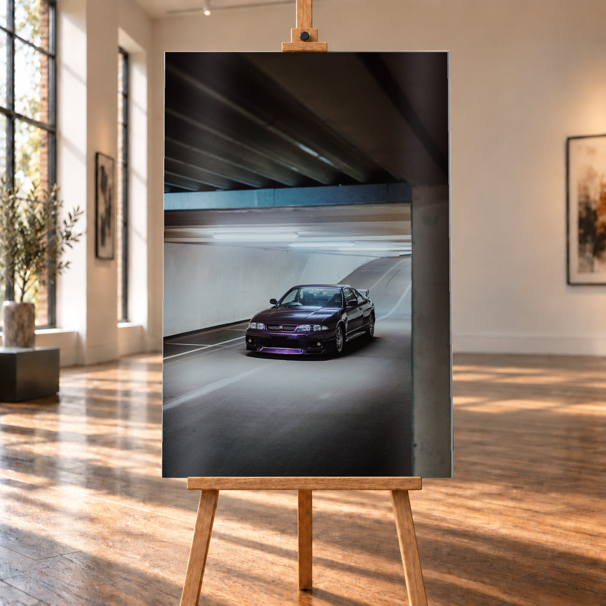 Dunkelvioletter Nissan Skyline in vorderer Dreiviertelansicht in einer Beton-Tiefgarage, beleuchtet von kühlen Deckenleuchten; Fahrbahnlinien und eine Rampe liegen im Hintergrund; Visualisierung als Alu gebürstet-Wandbild, auf einer Holzstaffelei in einem hellen Galerieraum.