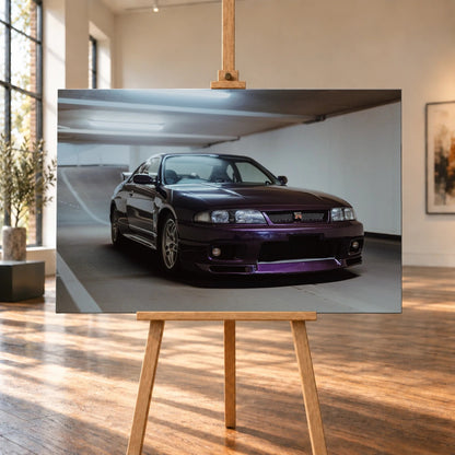 Der Nissan Skyline R33 steht tief in einer Dreiviertel-Frontansicht zwischen weißen Fahrbahnmarkierungen und kühlen Betonflächen. Motiv „Midnight Moment 2“ als Leinwand-Wandbild, auf einer Holzstaffelei in einem hellen Galerieraum.