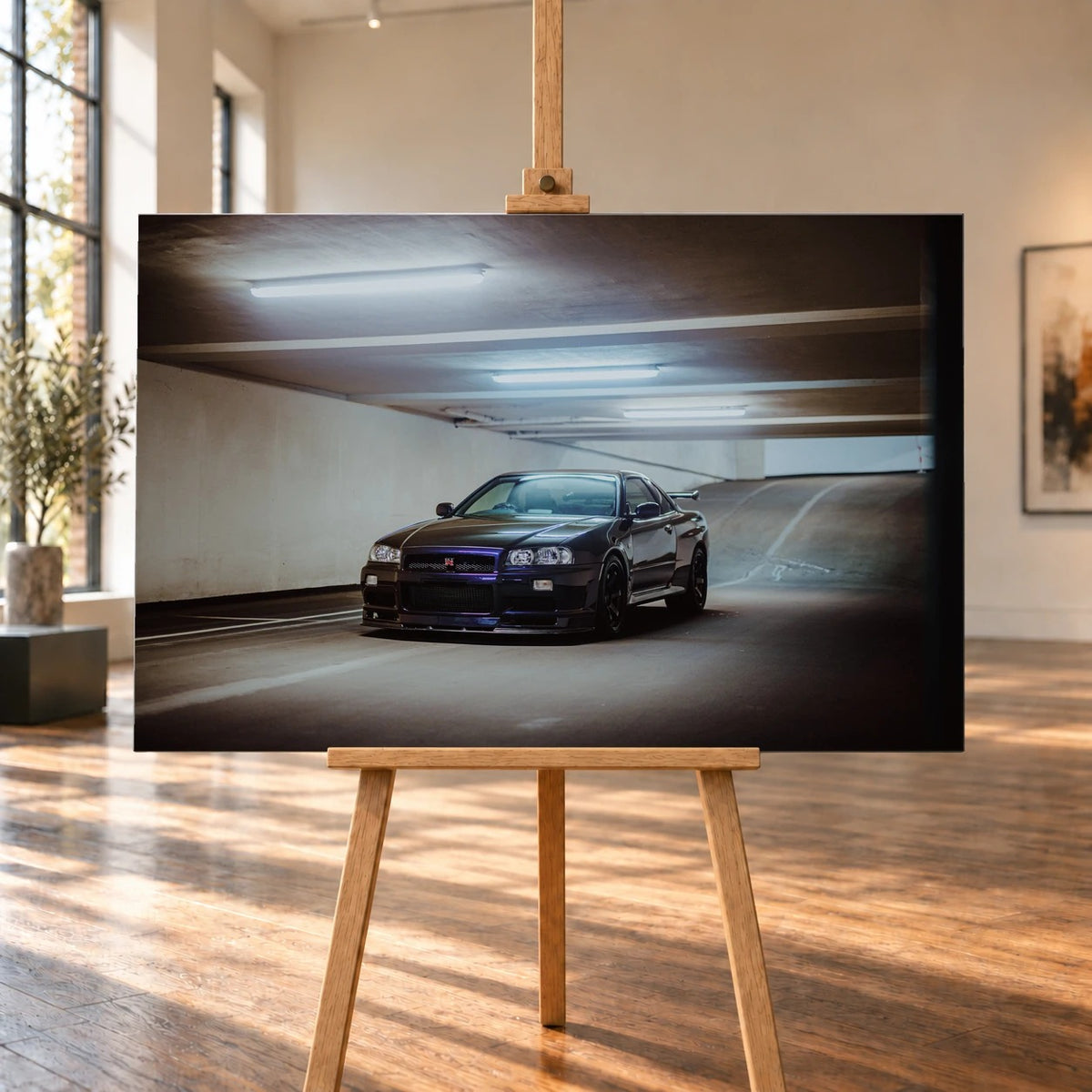 Der Nissan Skyline R34 nähert sich optisch aus einer breiten, geschwungenen Parkhausspur; das violette Auto steht im Zentrum des Lichtkegels. Motiv „Midnight Focus 2“ als Leinwand-Wandbild, auf einer Holzstaffelei in einem hellen Galerieraum.