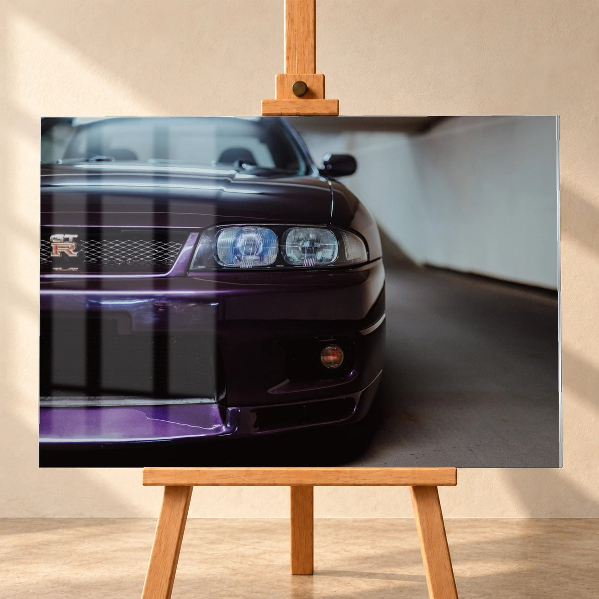 Die angeschnittene Front des Nissan Skyline R33 zeigt auf engem Raum Grill, Scheinwerfer und violetten Splitter als grafisches Detail. Motiv „Urban Horizon“ als Acrylglas-Wandbild, frontal auf einer Holzstaffelei.