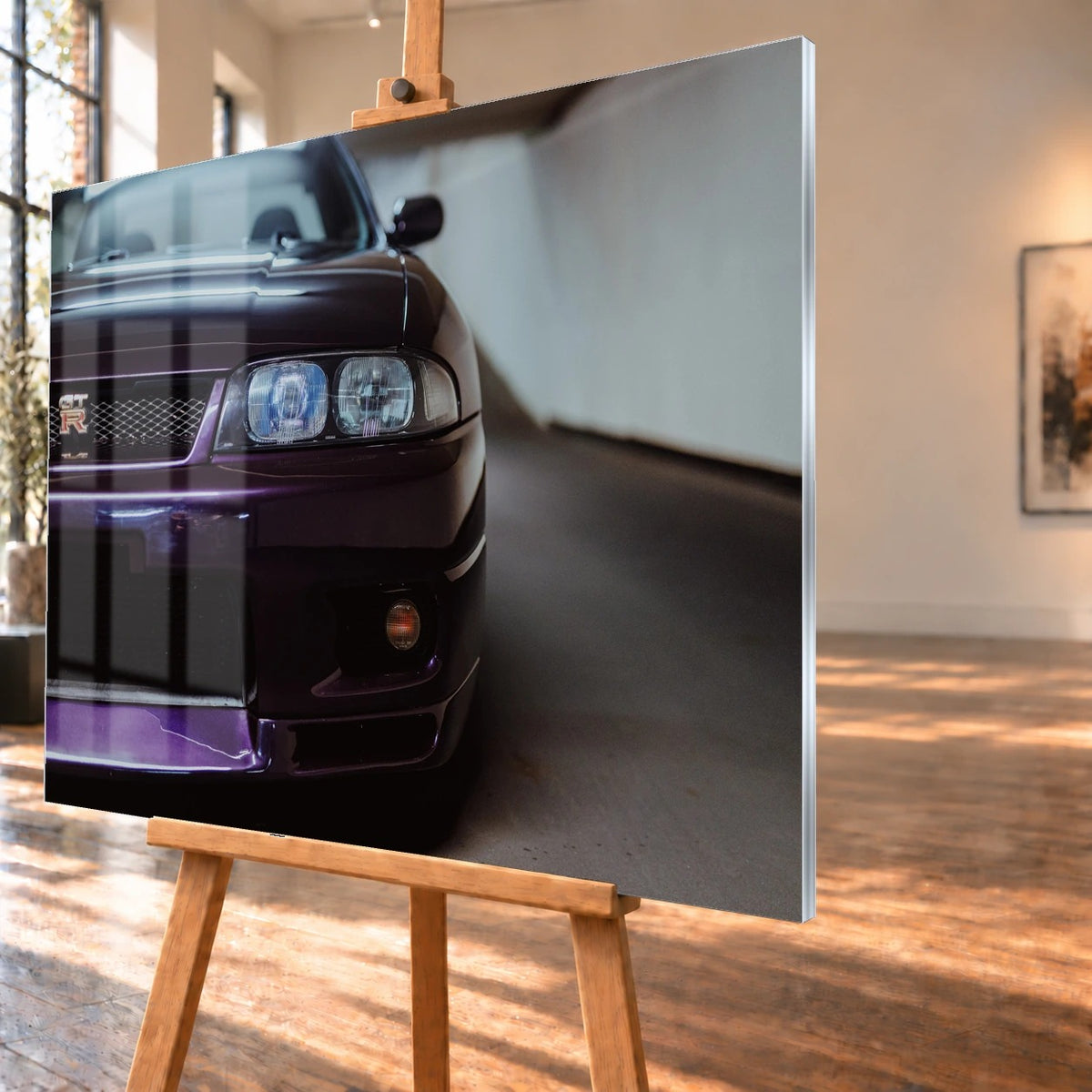 Die angeschnittene Front des Nissan Skyline R33 zeigt auf engem Raum Grill, Scheinwerfer und violetten Splitter als grafisches Detail. Motiv „Urban Horizon“ als Acrylglas-Wandbild, schräg von der Seite auf einer Holzstaffelei.