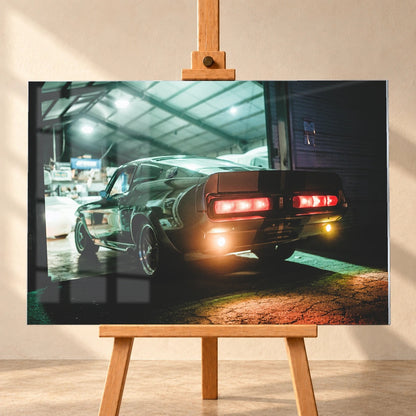 Eleanor steht von hinten in einer dunklen Werkhalle; rote Rücklichter und Spiegelungen auf nassem Boden erzeugen eine nächtliche Stimmung. Motiv „Cinematic Spirit“ als Acrylglas-Wandbild, frontal auf einer Holzstaffelei.
