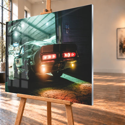 Eleanor steht von hinten in einer dunklen Werkhalle; rote Rücklichter und Spiegelungen auf nassem Boden erzeugen eine nächtliche Stimmung. Motiv „Cinematic Spirit“ als Acrylglas-Wandbild, schräg von der Seite auf einer Holzstaffelei.
