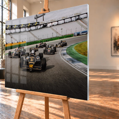 Fünf historische Lotus-Formelwagen fahren als Gruppe durch eine Rennstreckenkurve; schwarze Gold-Lackierungen und Startnummern sind deutlich erkennbar. Motiv „Trackside Story“ als Acrylglas-Wandbild, schräg von der Seite auf einer Holzstaffelei.