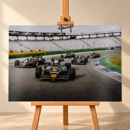 Fünf historische Lotus-Formelwagen fahren als Gruppe durch eine Rennstreckenkurve; schwarze Gold-Lackierungen und Startnummern sind deutlich erkennbar. Motiv „Trackside Story“ als Alu gebürstet-Wandbild, frontal auf einer Holzstaffelei.