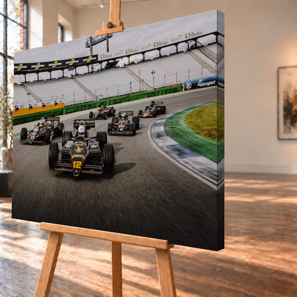Fünf historische Lotus-Formelwagen fahren als Gruppe durch eine Rennstreckenkurve; schwarze Gold-Lackierungen und Startnummern sind deutlich erkennbar. Motiv „Trackside Story“ als Leinwand-Wandbild, schräg von der Seite auf einer Holzstaffelei.