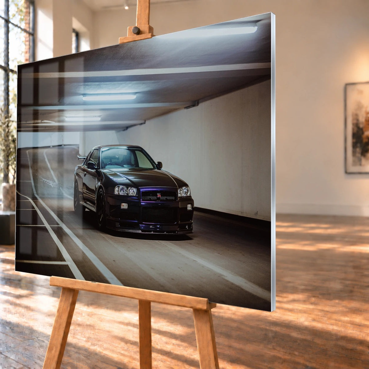 Der Nissan Skyline R34 steht tief und breit in der Kurve eines Parkhauses; Front, Seitenschweller und violette Akzente sind klar sichtbar. Motiv „Violet Story“ als Acrylglas-Wandbild, schräg von der Seite auf einer Holzstaffelei.