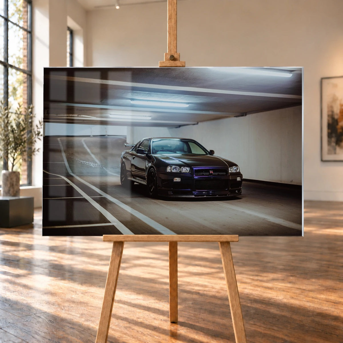 Der Nissan Skyline R34 steht tief und breit in der Kurve eines Parkhauses; Front, Seitenschweller und violette Akzente sind klar sichtbar. Motiv „Violet Story“ als Acrylglas-Wandbild, auf einer Holzstaffelei in einem hellen Galerieraum.